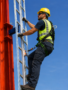 Construction worker wearing a professional anti-fall arrest device and safety harness while working at heights.